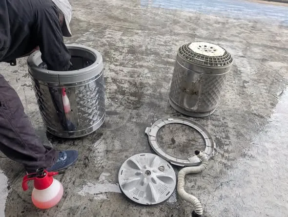 洗衣機拆解清洗:師傅將內槽與零件拆下分別清洗